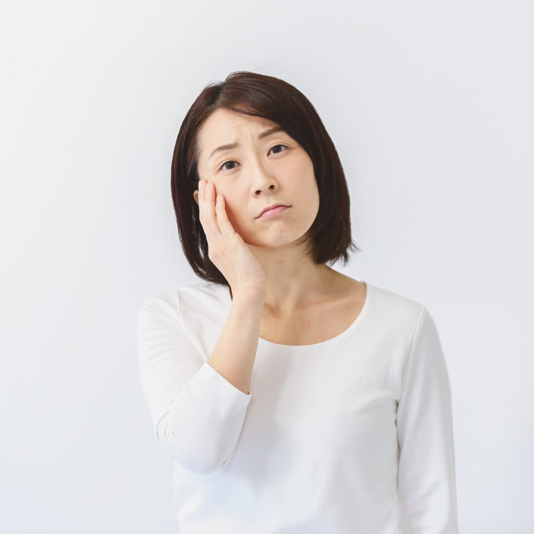 頬に手を当て、疲れた表情で考えこんでいる保護者
