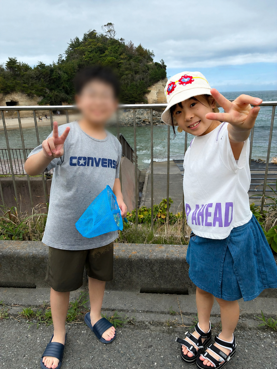 高戸小浜海岸を背景に、環境問題について考える活動に参加した子どもたち