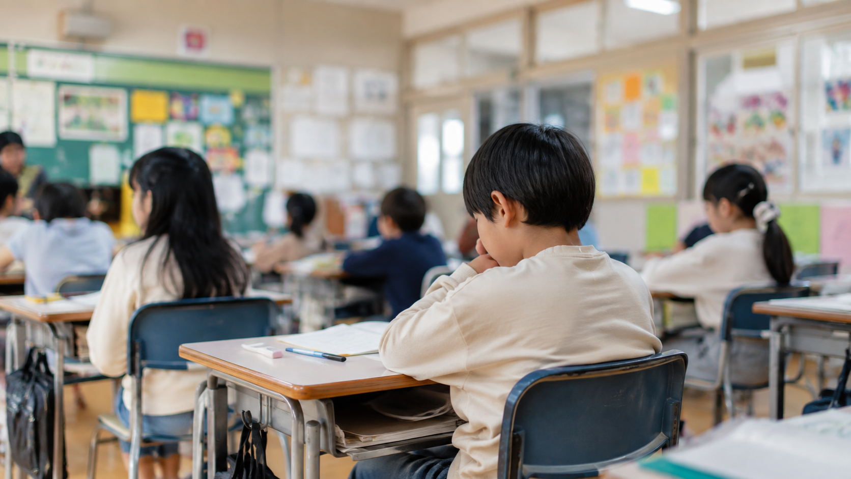 刺激の多い教室で授業を受けながら疲れをためている小学生