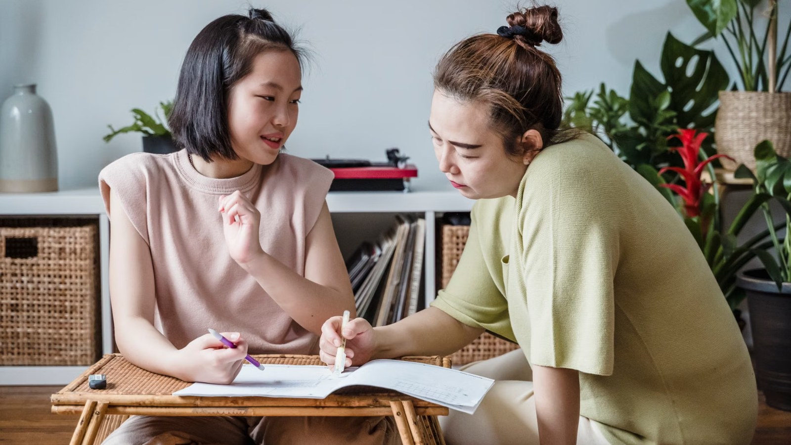 A parent and child going through papers together at a table