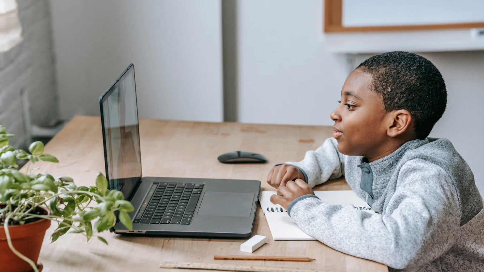 A boy learning on a laptop at home