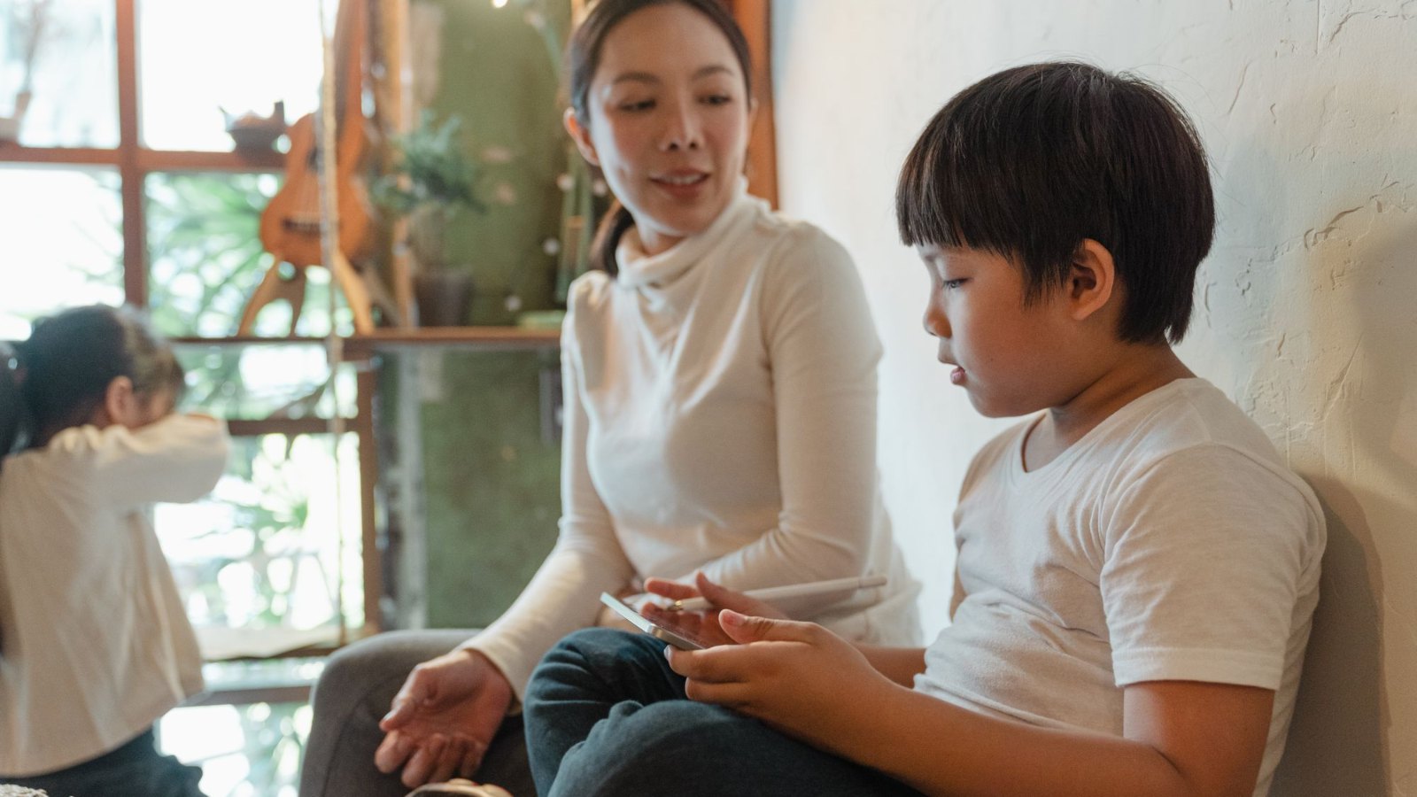 母親と小学生の男の子がリビングで向かい合って話している様子
