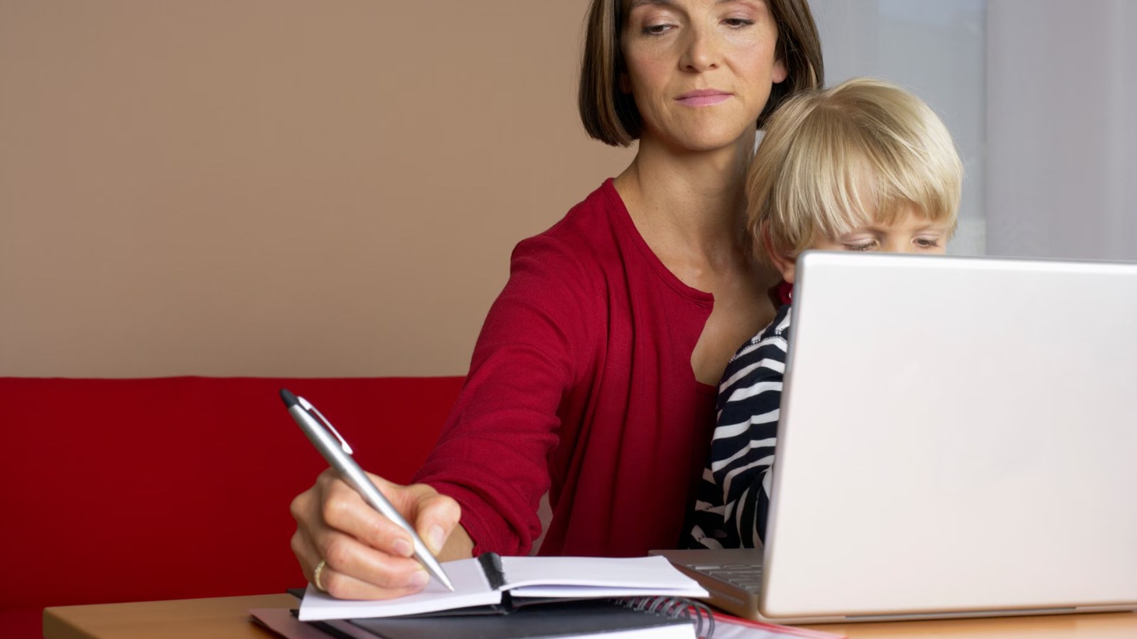 A parent writing notes next to a child