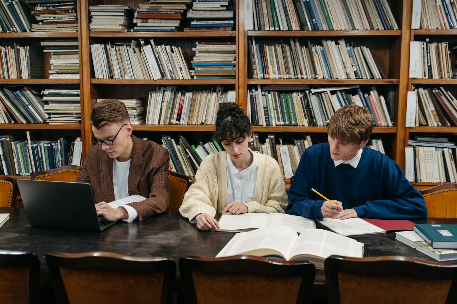 A small group of students talking around a table with notebooks