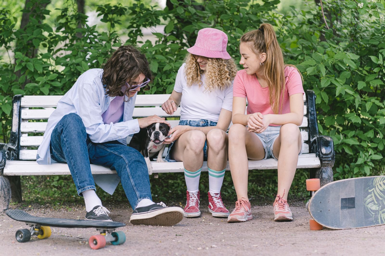 Two teenagers talking on a bench outdoors in daylight