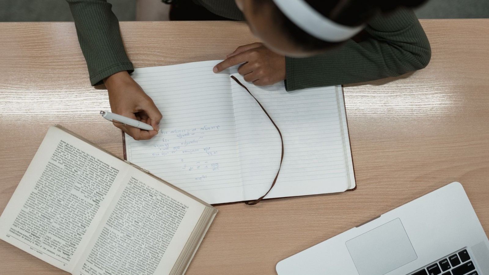 本を開いてノートに書き込みながら確認する様子