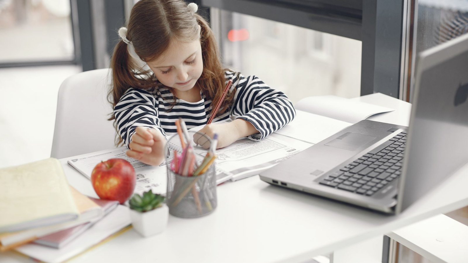 自宅でノートパソコンを使って学ぶ子ども