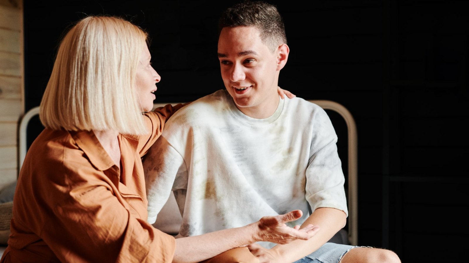 自宅のソファで向き合って話す母親と息子