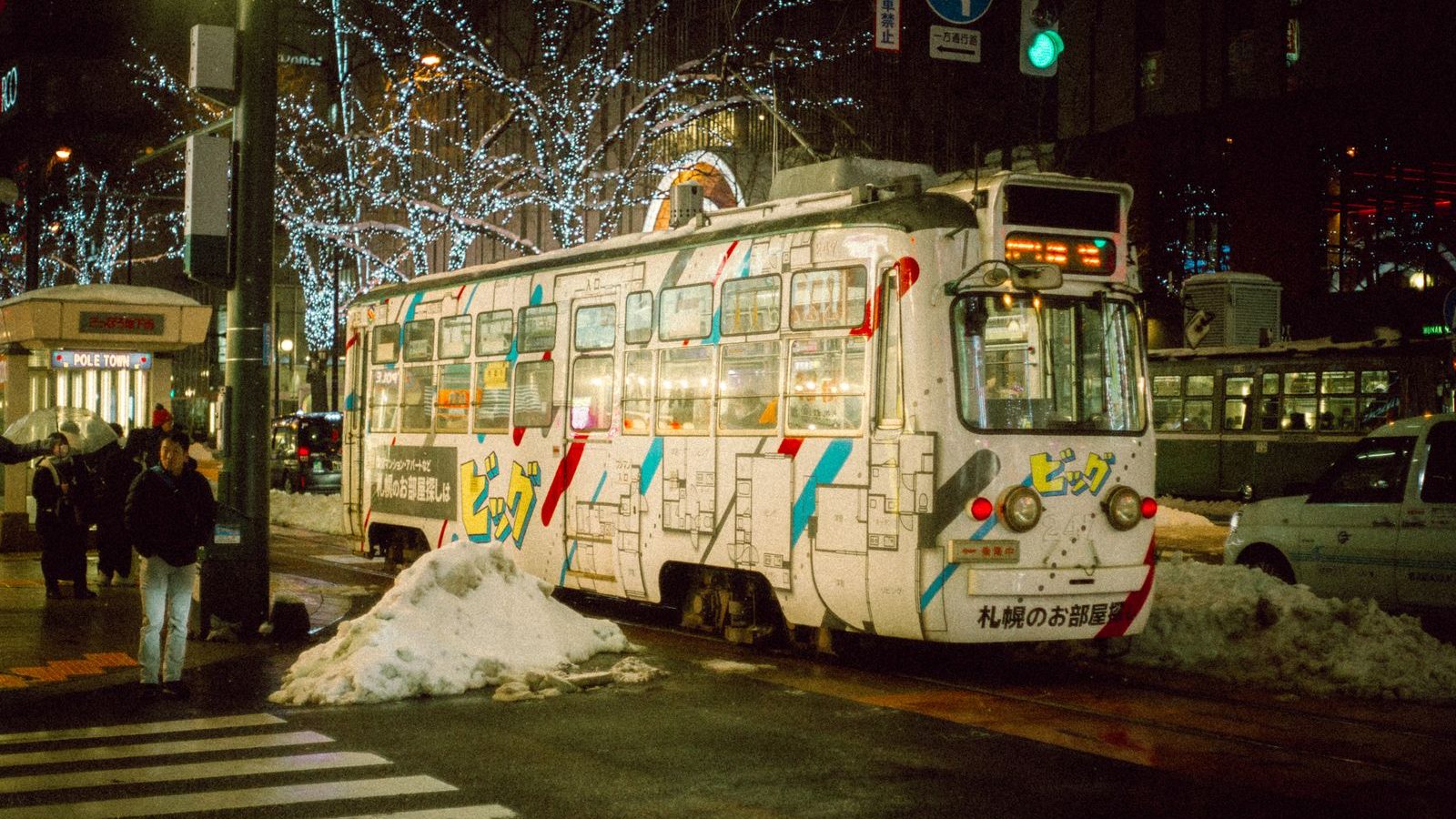 雪の残る札幌の街を走る路面電車