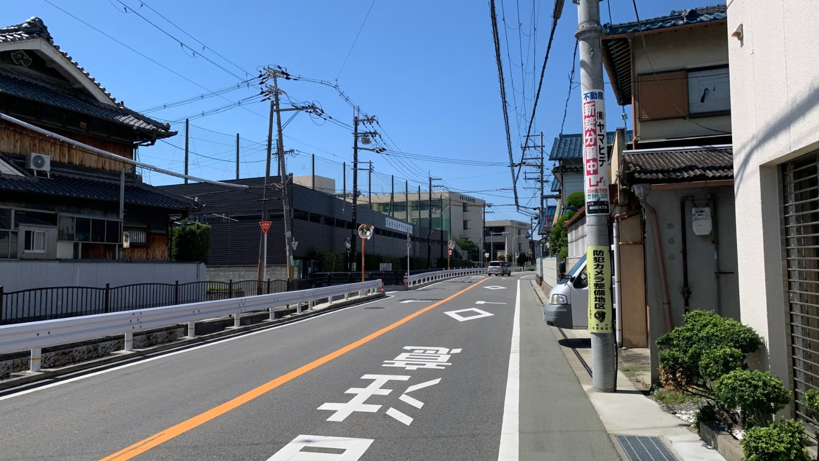 青空の下の住宅街の道