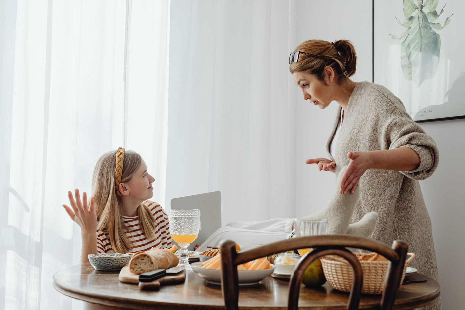 自宅のテーブルで10代の子どもと保護者が向き合って話している様子