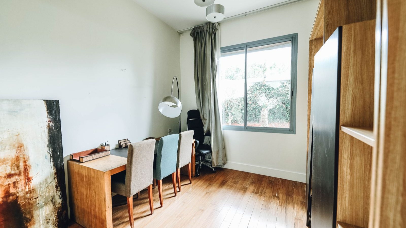 窓のある明るい部屋に置かれた机と椅子