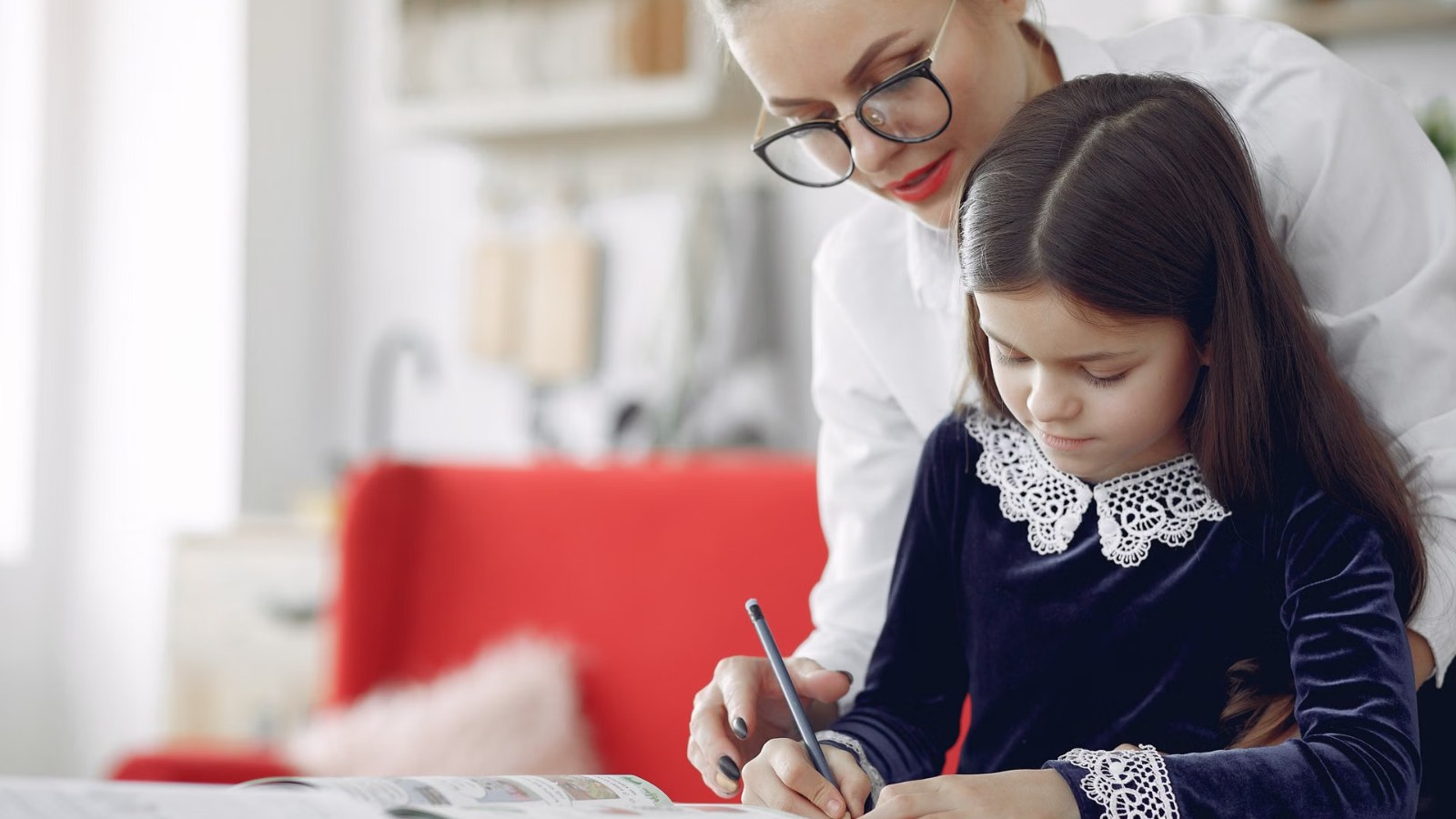 A teacher helping a girl with her writing