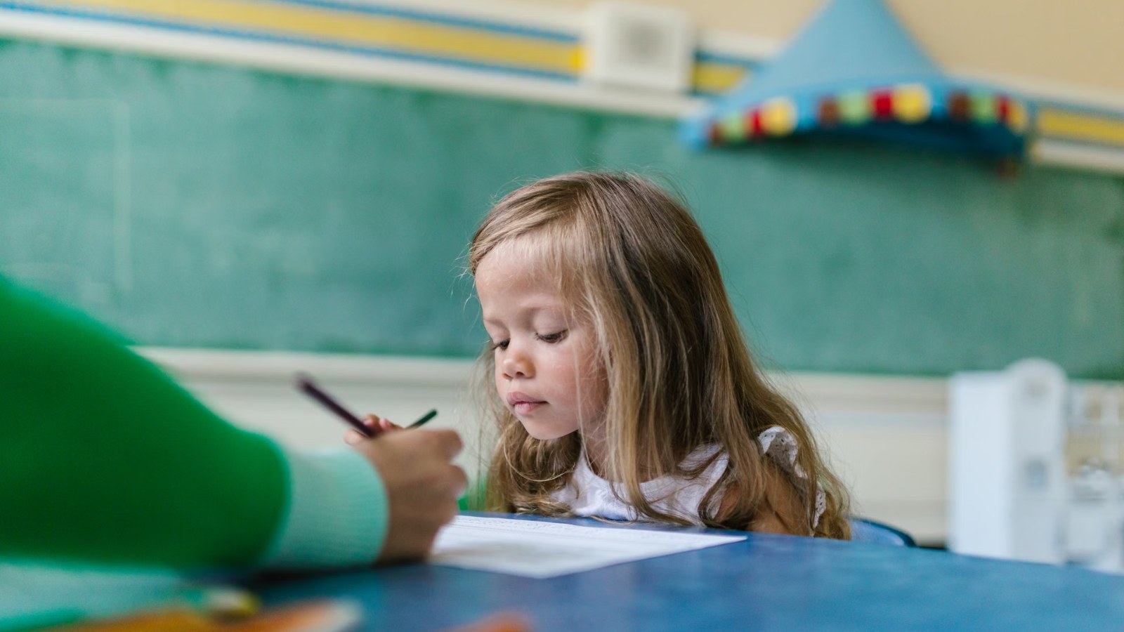 A girl writing at her desk in class
