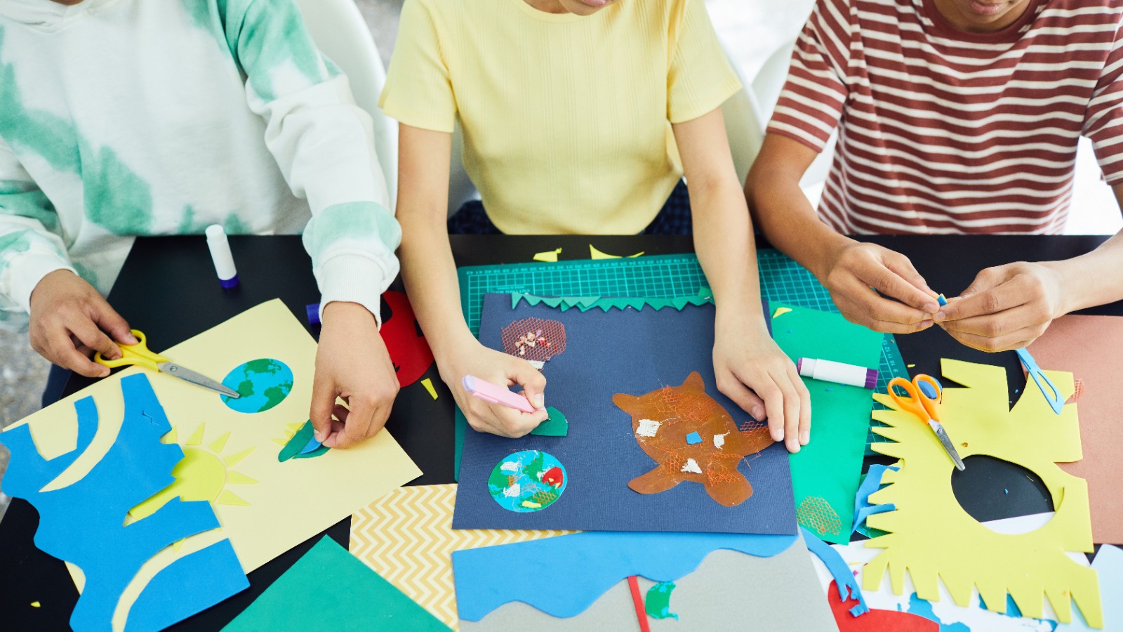紙とのりを使って工作をする子どもたち