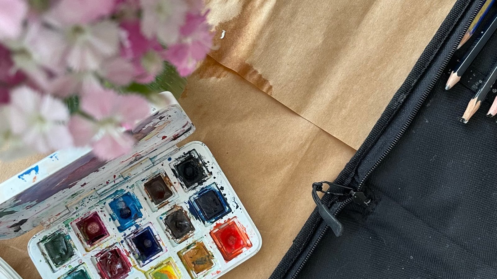 花と水彩絵の具が置かれた机