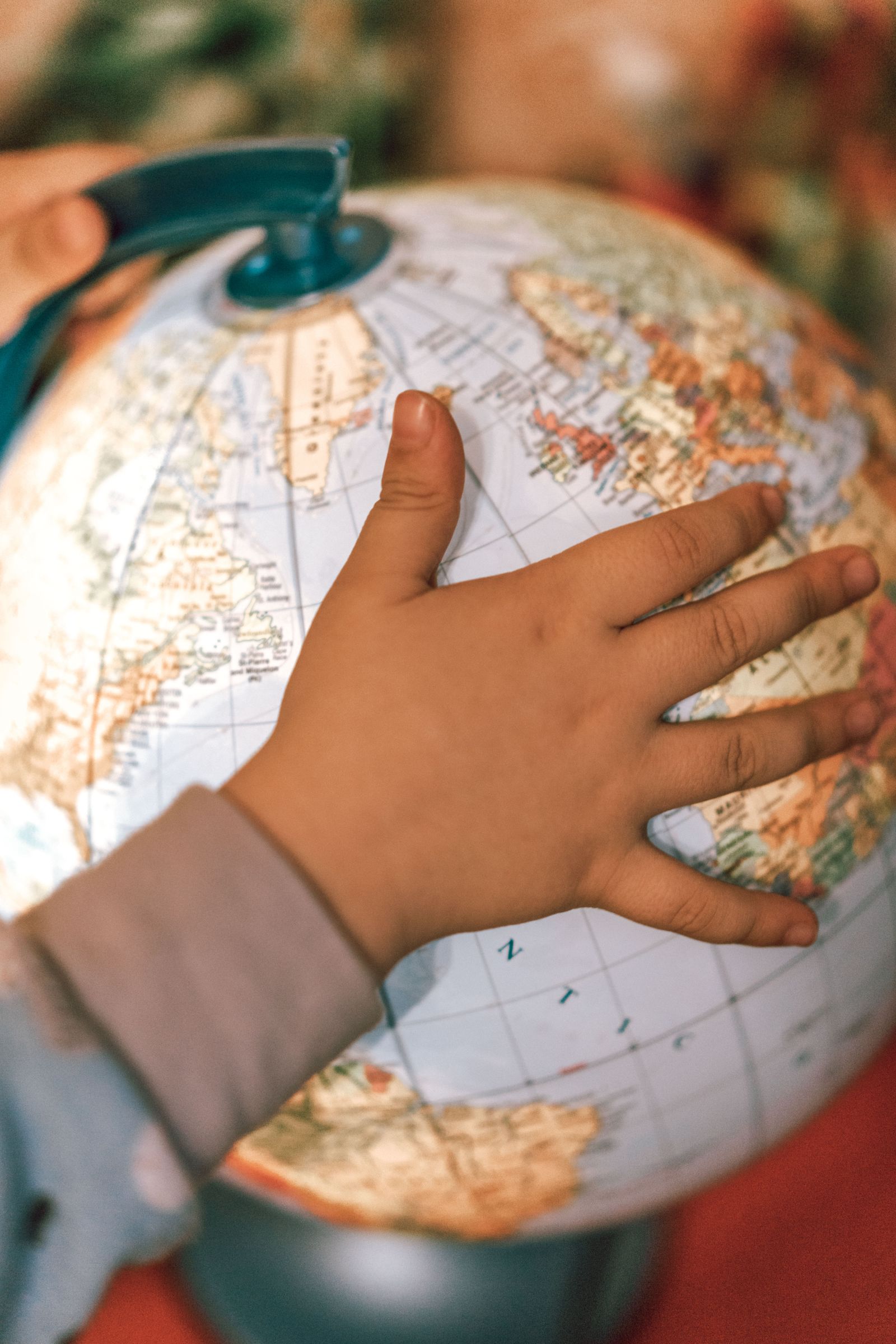 地球儀に触れながら世界について学ぶ子どものイメージ