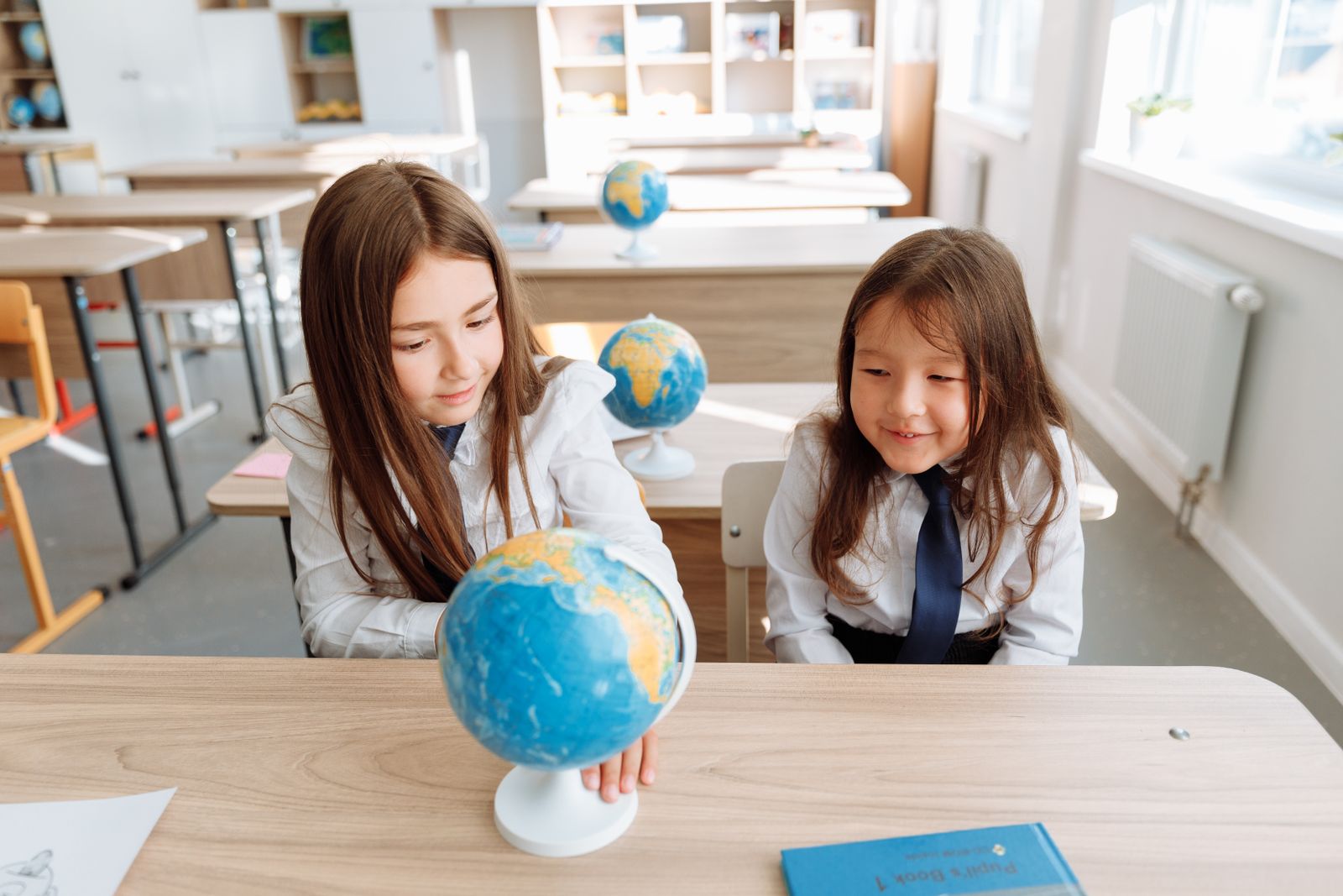 地球儀を見ながら一緒に学ぶ子どもたちのイメージ