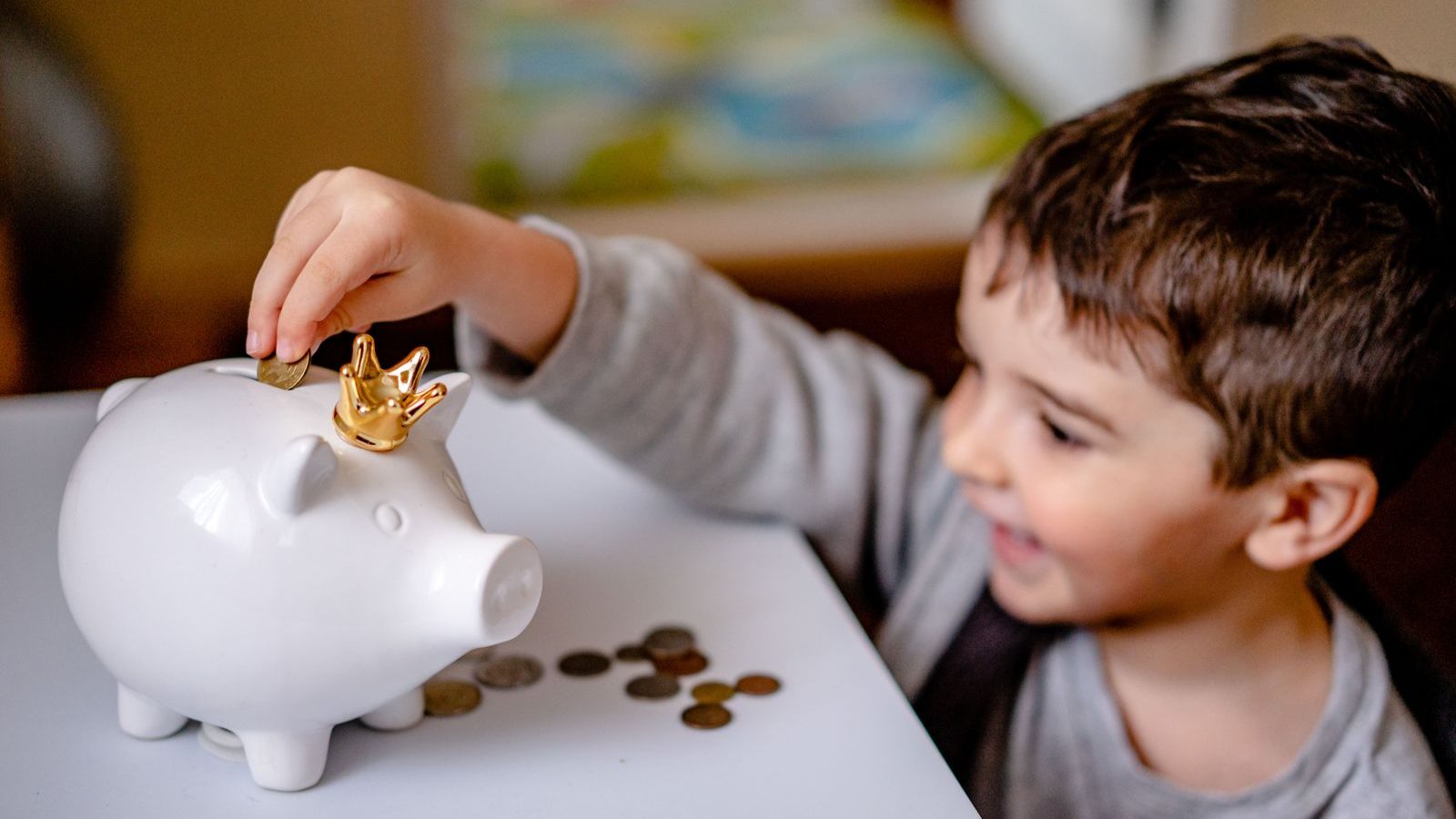 貯金箱に硬貨を入れる子ども