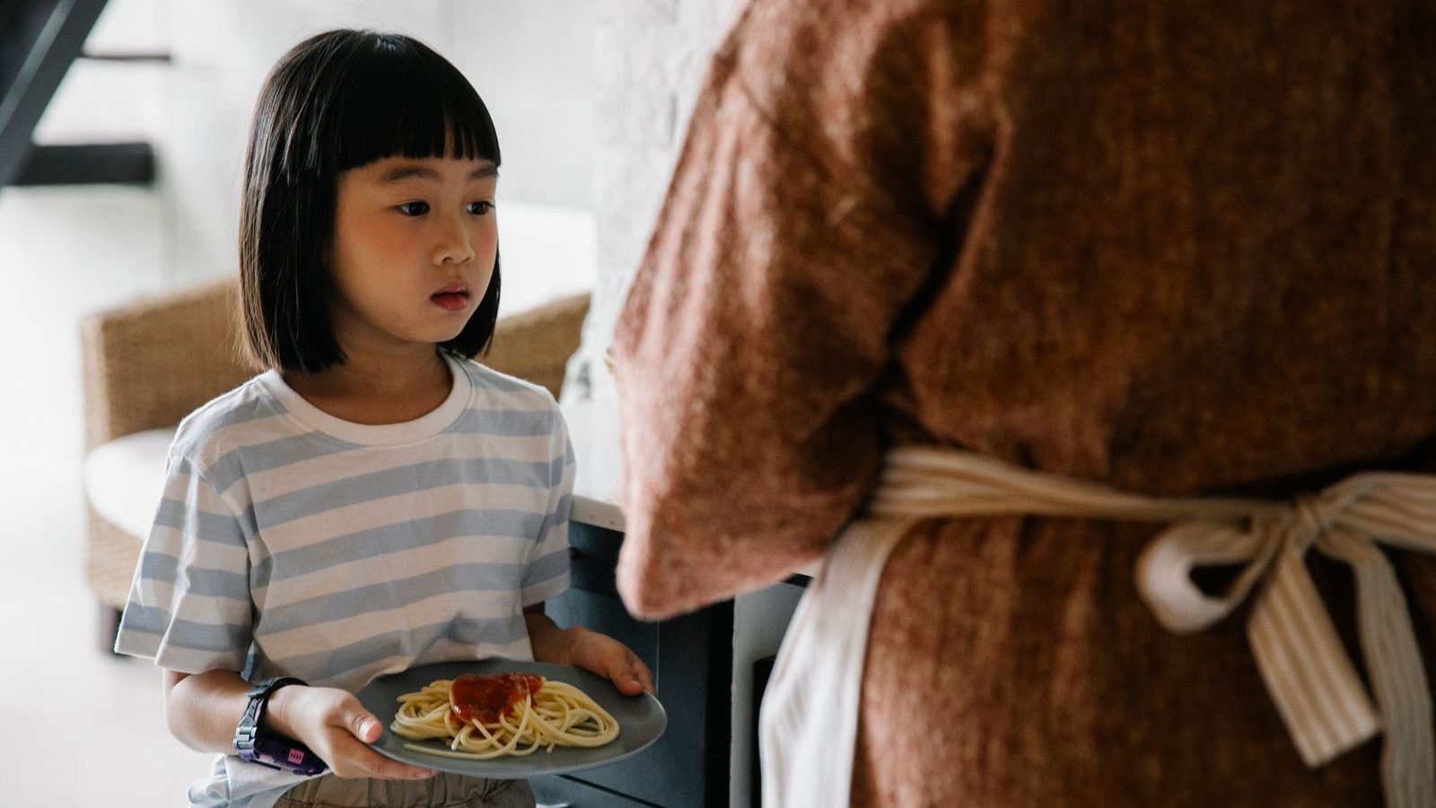 出来上がった料理を運ぶ子ども