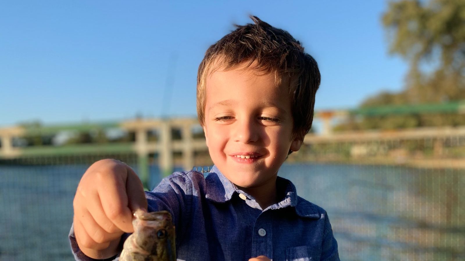 釣った魚を持って見せる子ども
