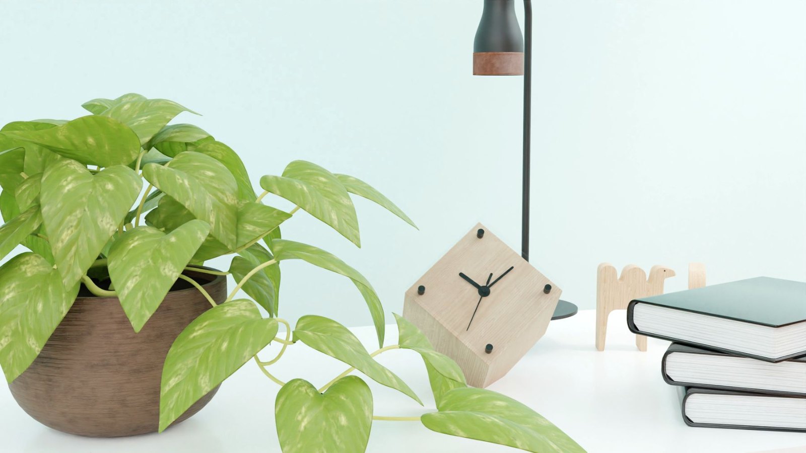 観葉植物と置き時計のある机