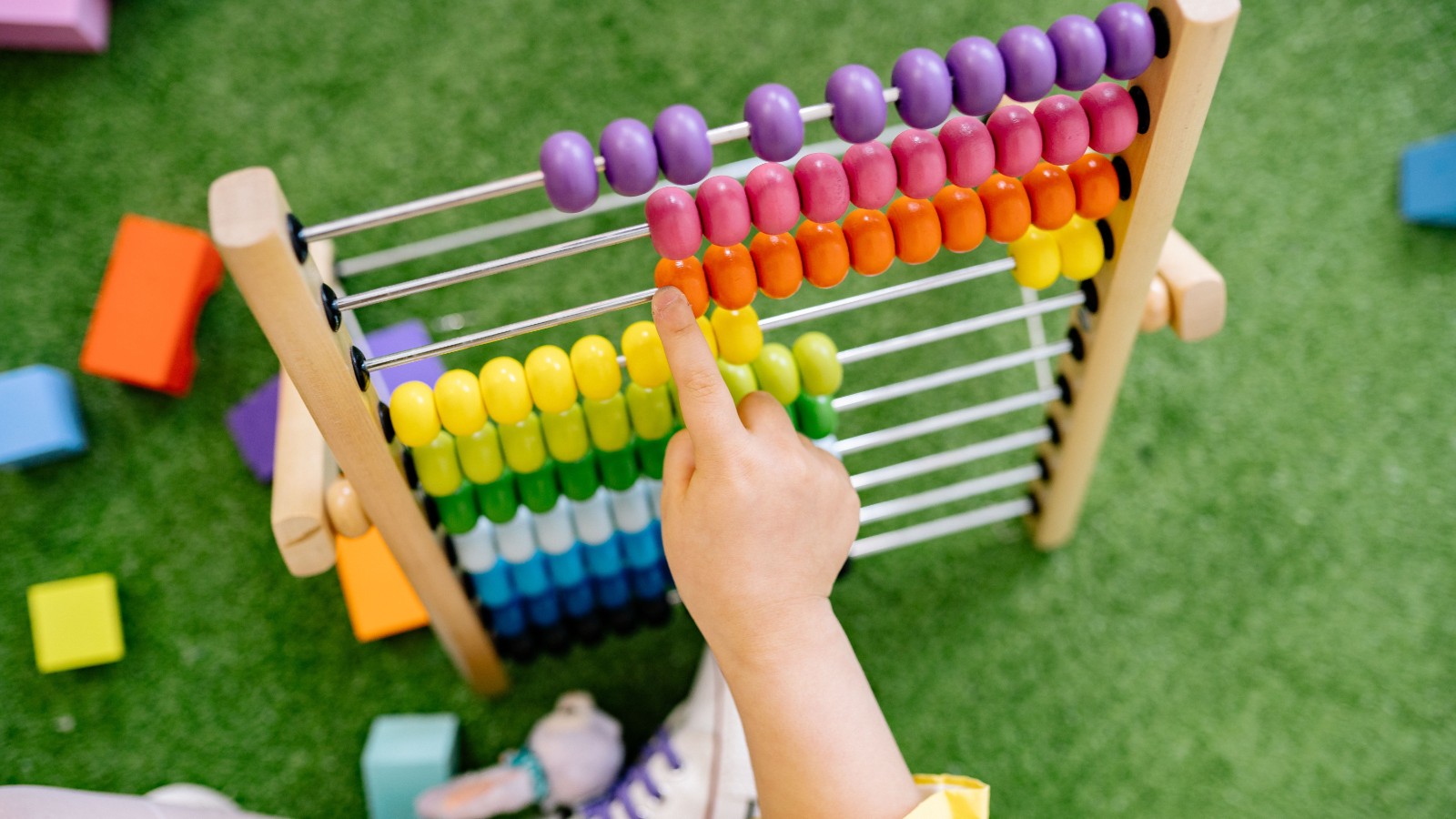 そろばんを使って数を数える練習をする子ども