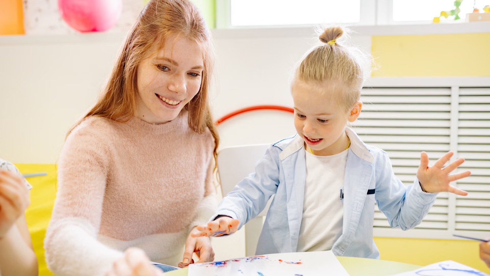 Two children smiling at a table