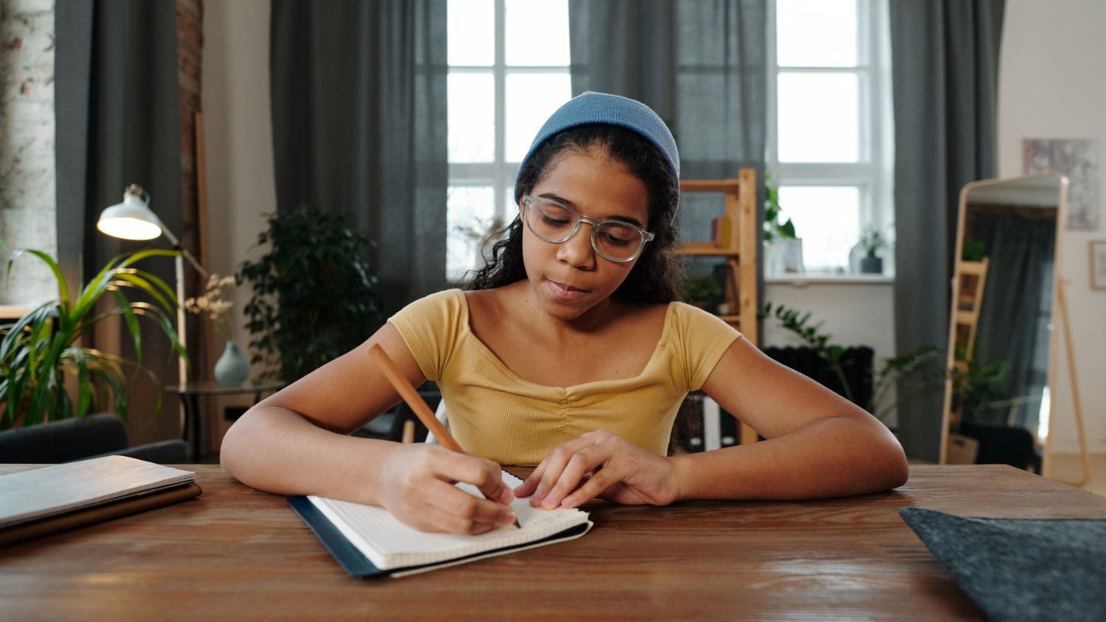 A girl writing at a desk at home