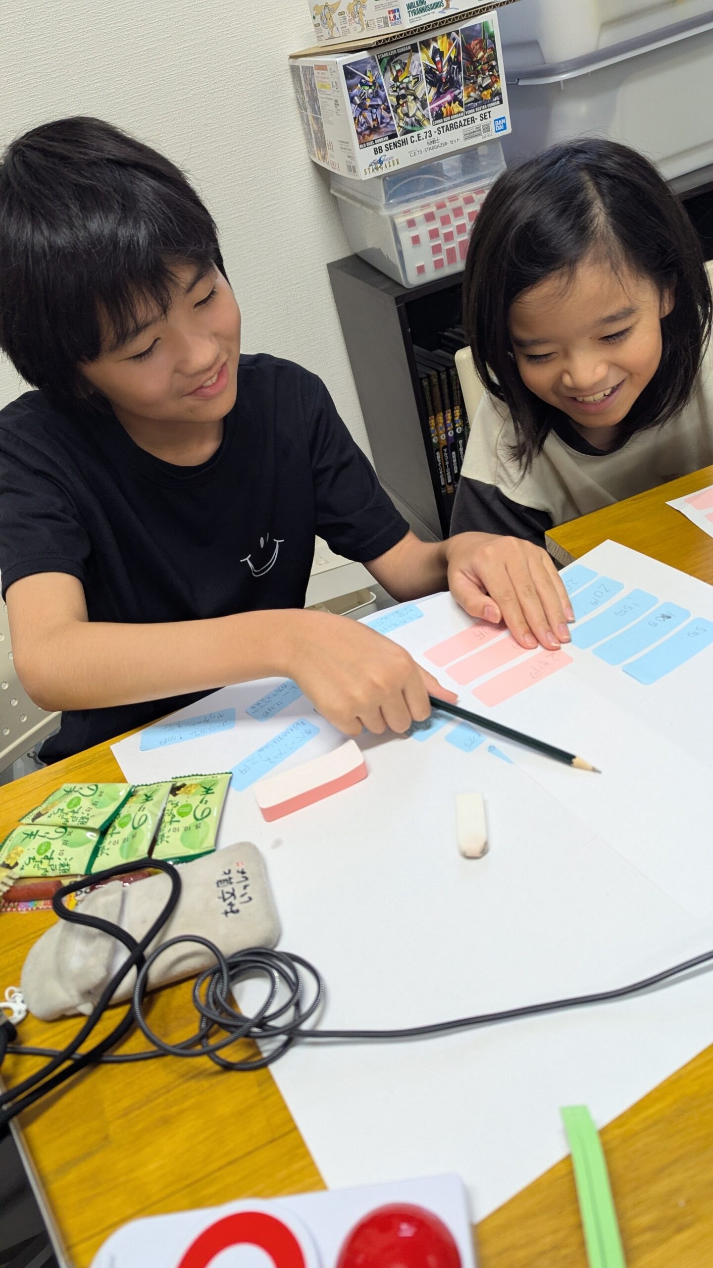 子どもたちが紙に書いた考えを見ながら企画を相談する活動写真