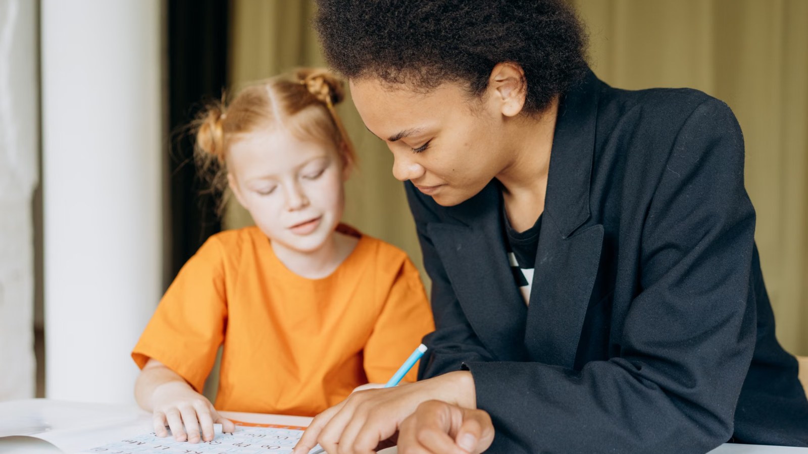An adult helping a girl with homework