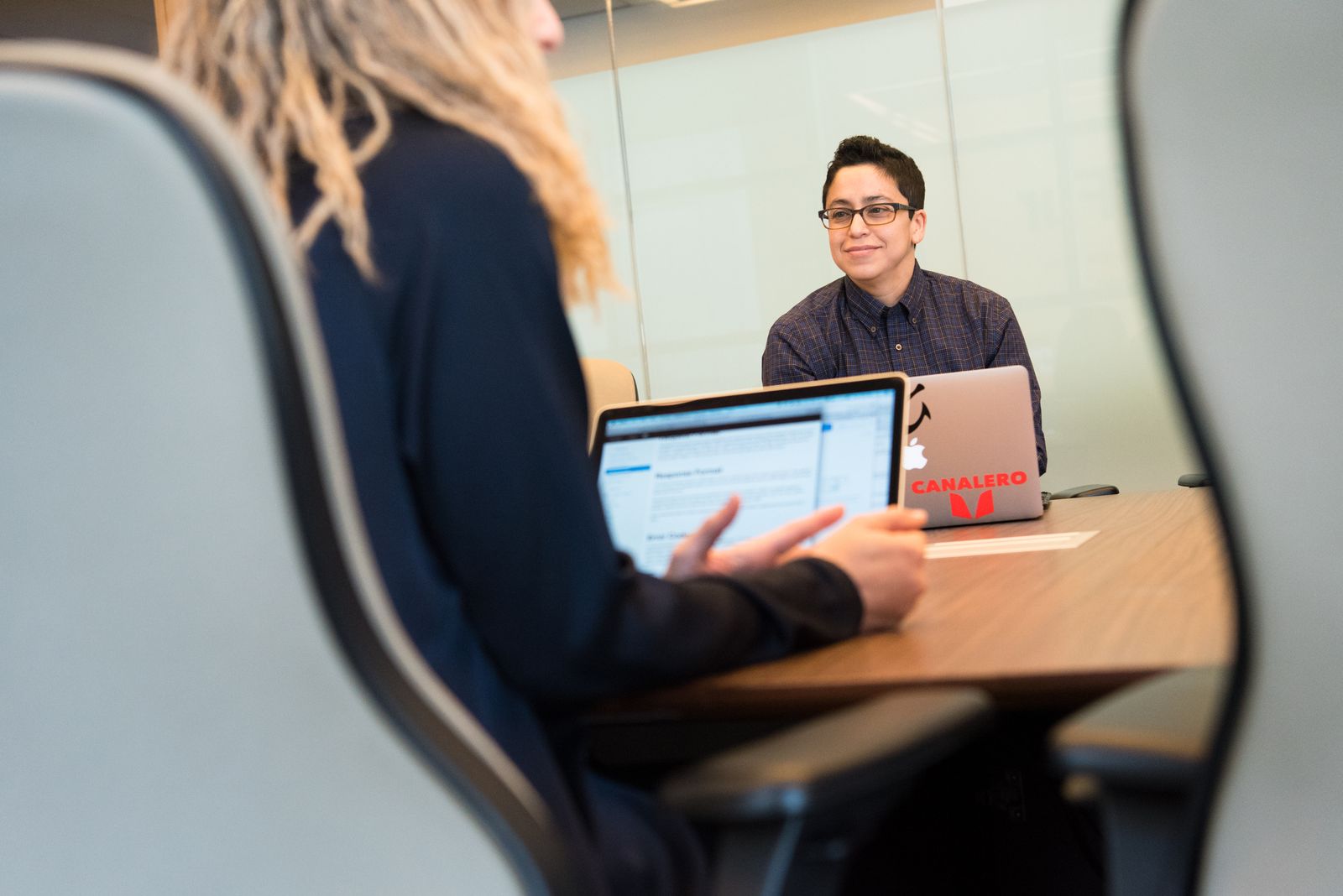 A school counselor and a parent talking across a table in a bright meeting room
