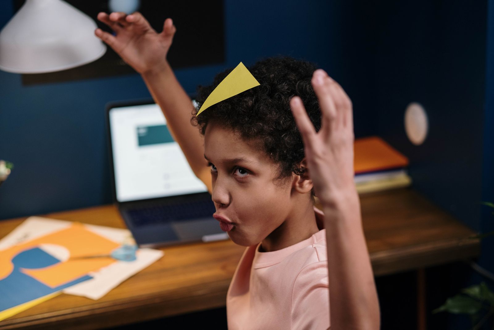 A child smiling at a laptop during an online class at home