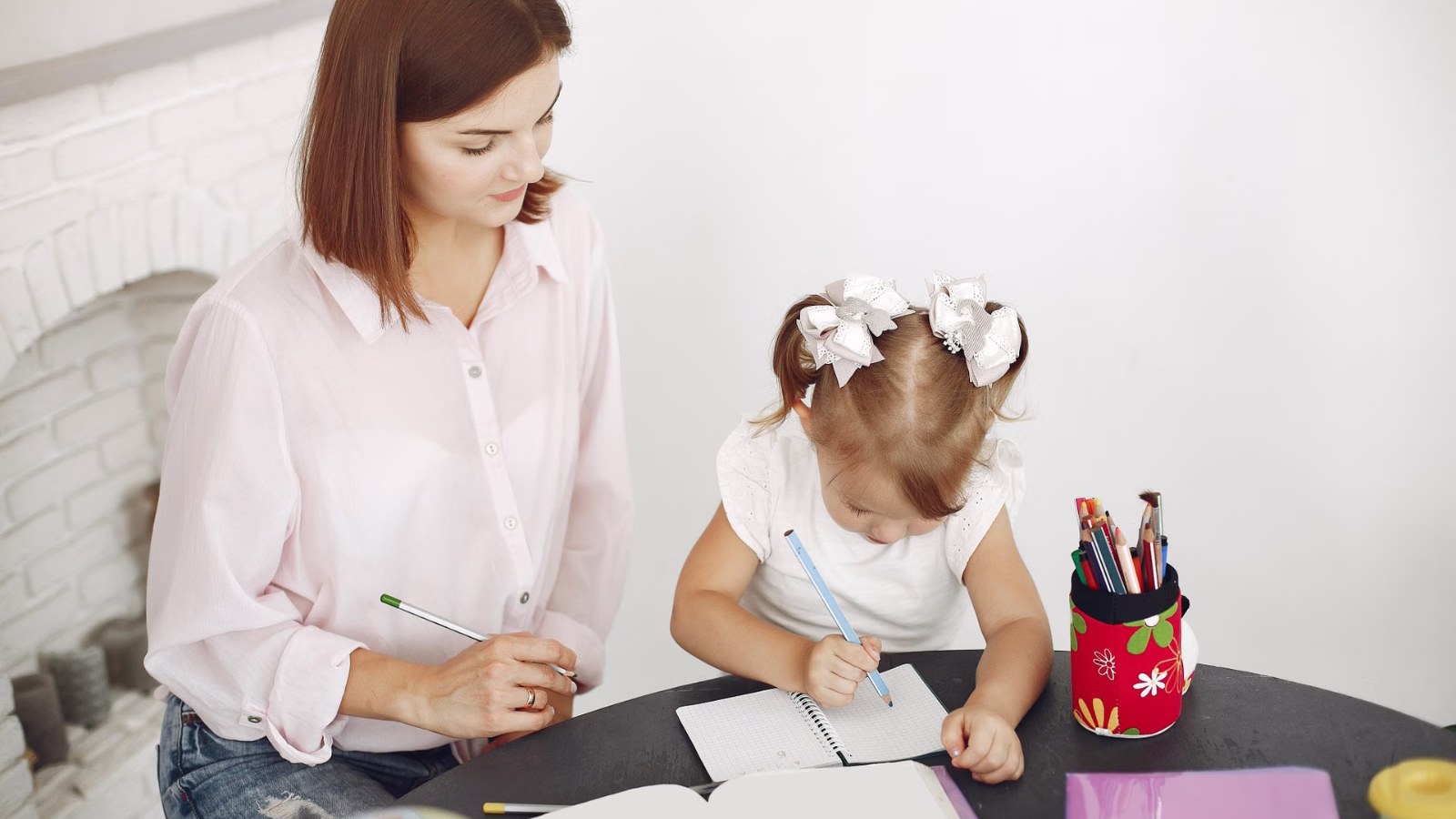 A teacher and child drawing together