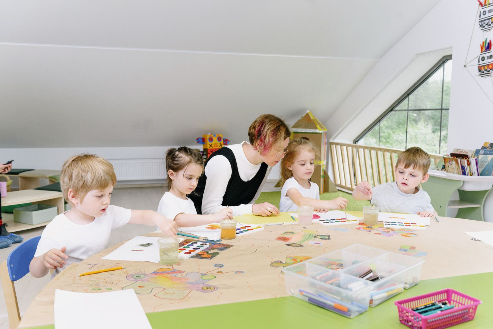 Young children sitting on a classroom rug with a teacher during a bright morning lesson