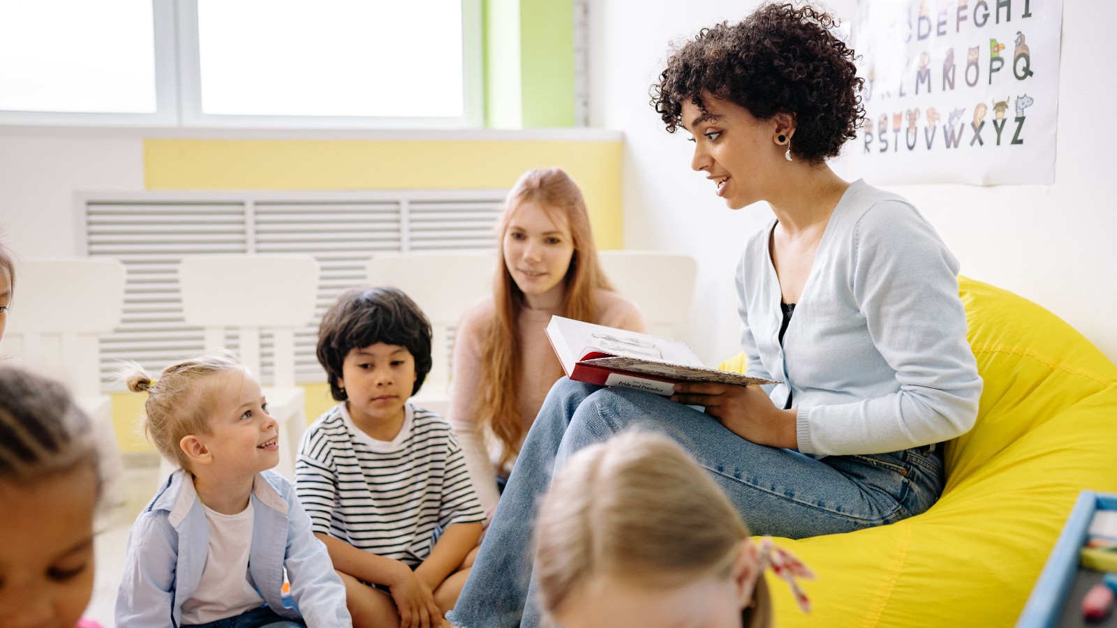 子どもたちに本を読み聞かせる女性