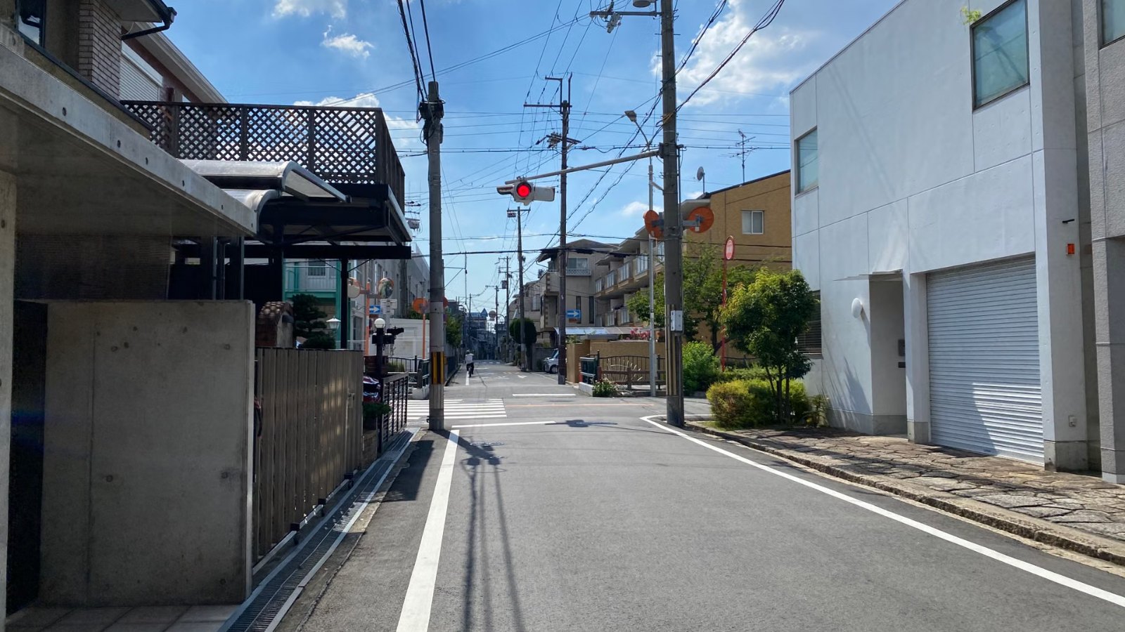青空の下の静かな住宅街の道