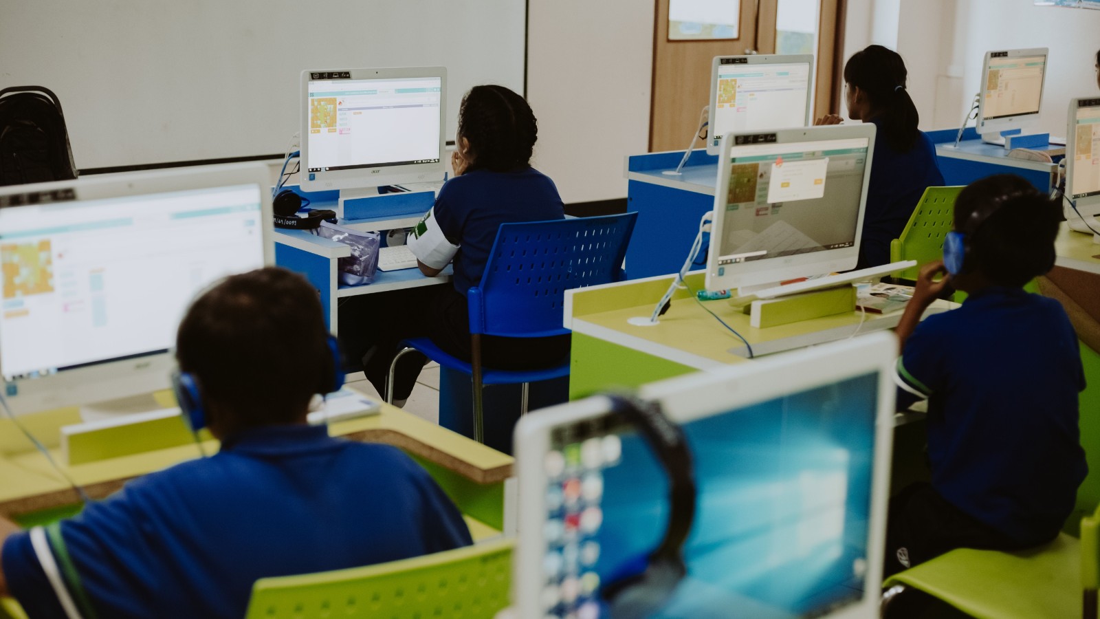 教室でパソコンに向かって学ぶ子どもたち