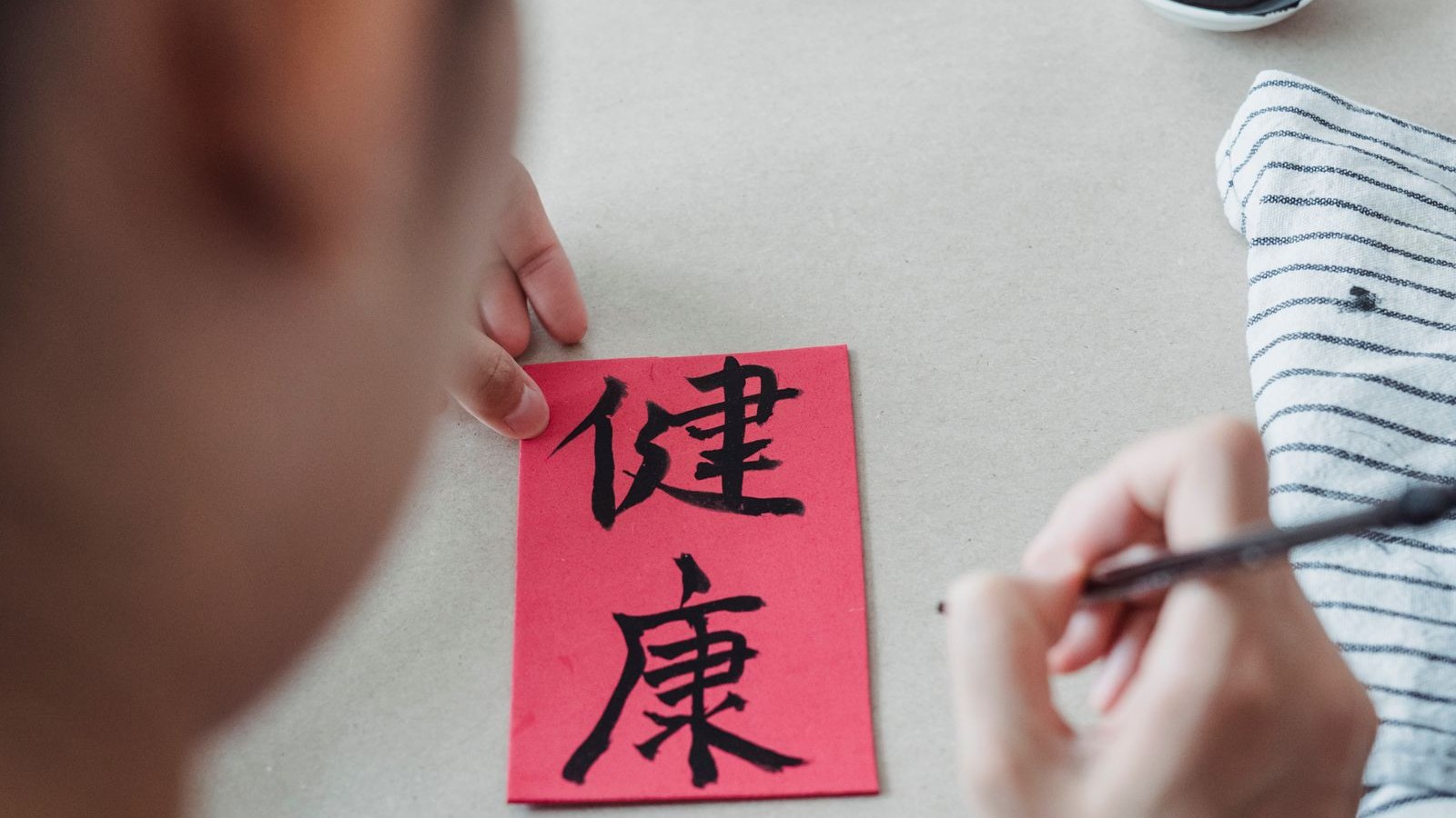 筆で文字を書く手元(書道のイメージ)