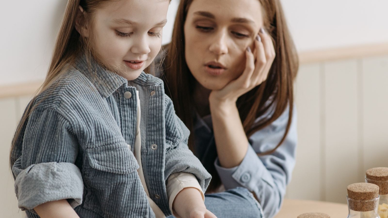 A parent and child in conversation at a table at home
