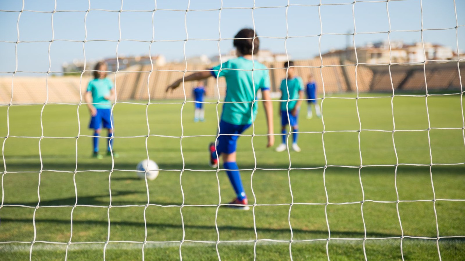 サッカーボールを追う子どもたち