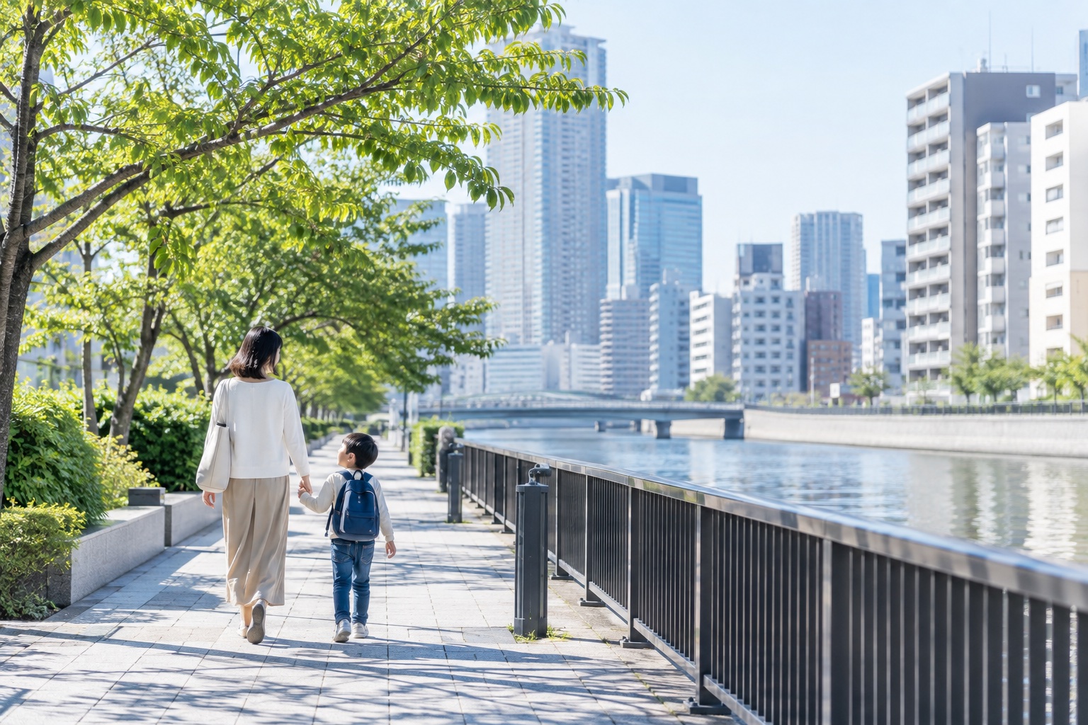 中央区の川沿いの街並みを歩く親子のイメージ