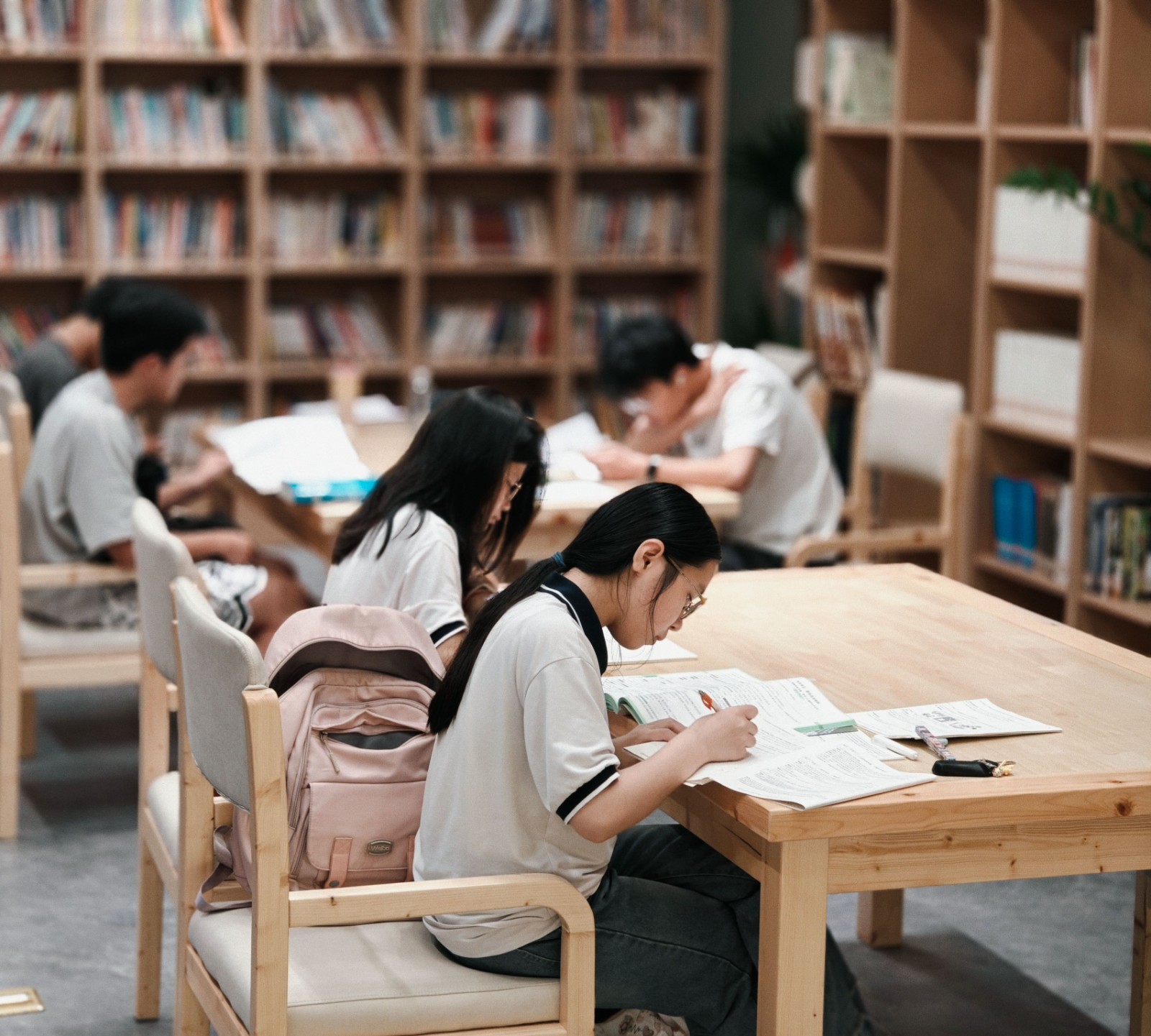 図書館で本に囲まれて勉強する生徒たち