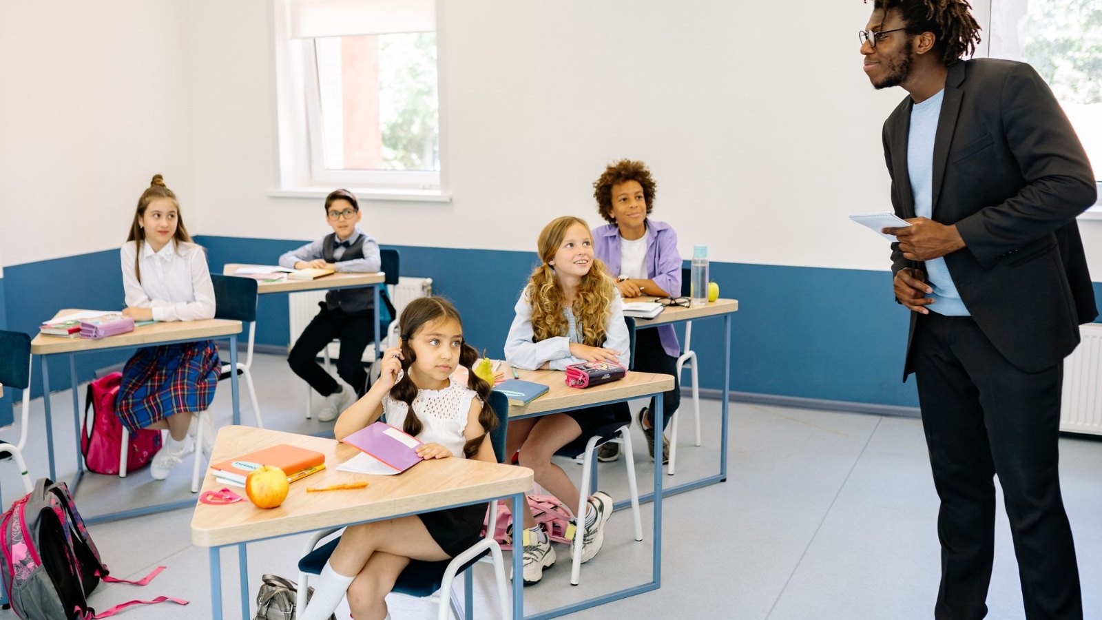 教室で先生の話を聞く子どもたち