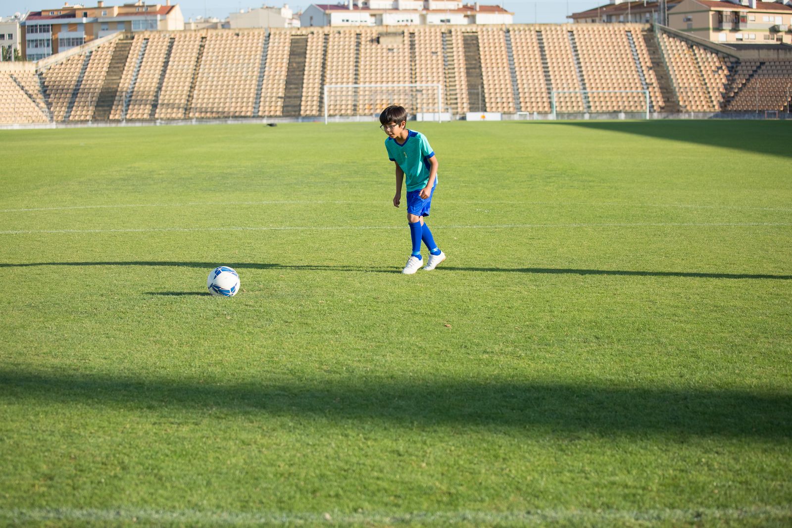 広いグラウンドでサッカーの練習をする男の子