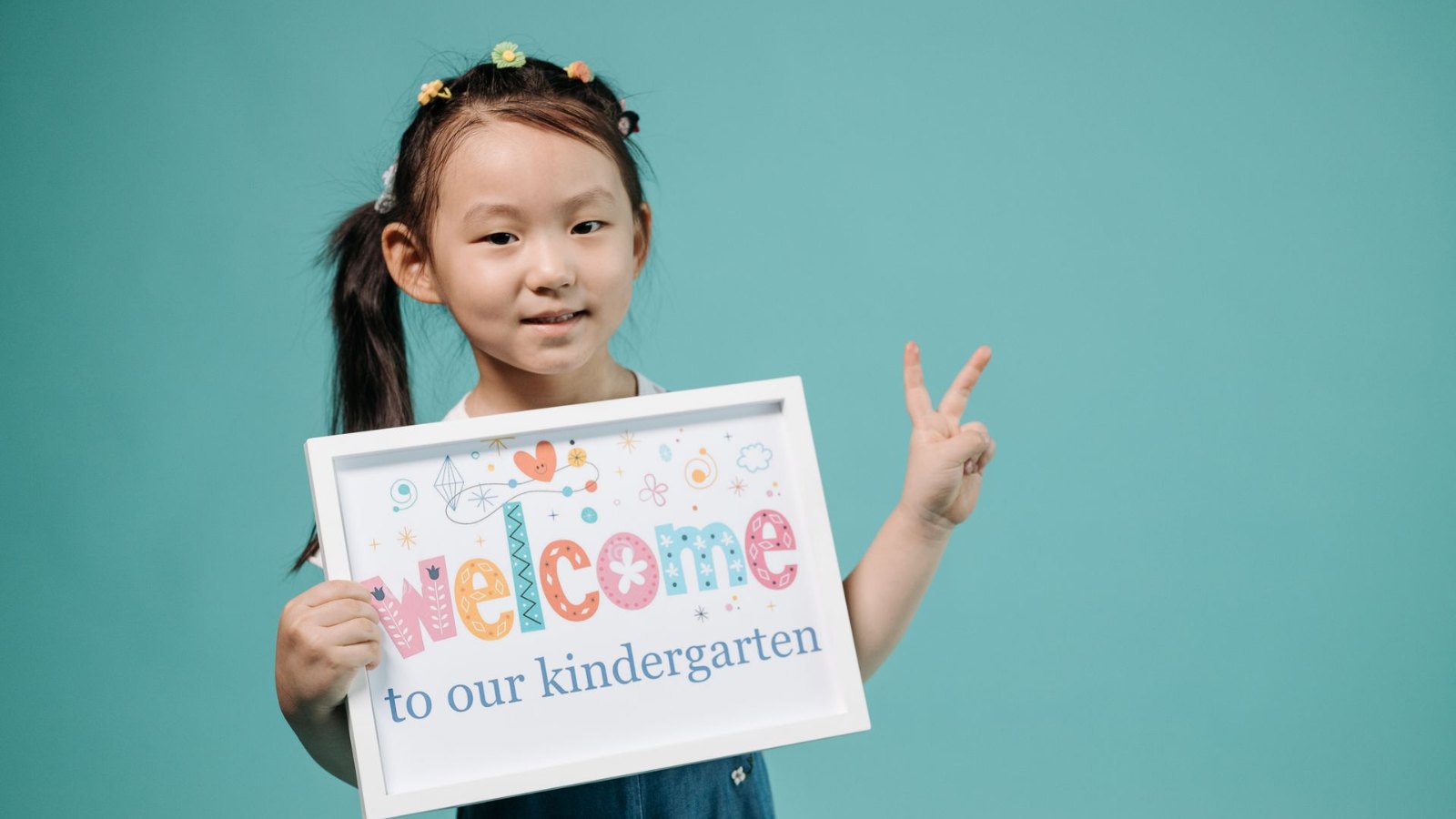 「Welcome」のカードを持つ女の子