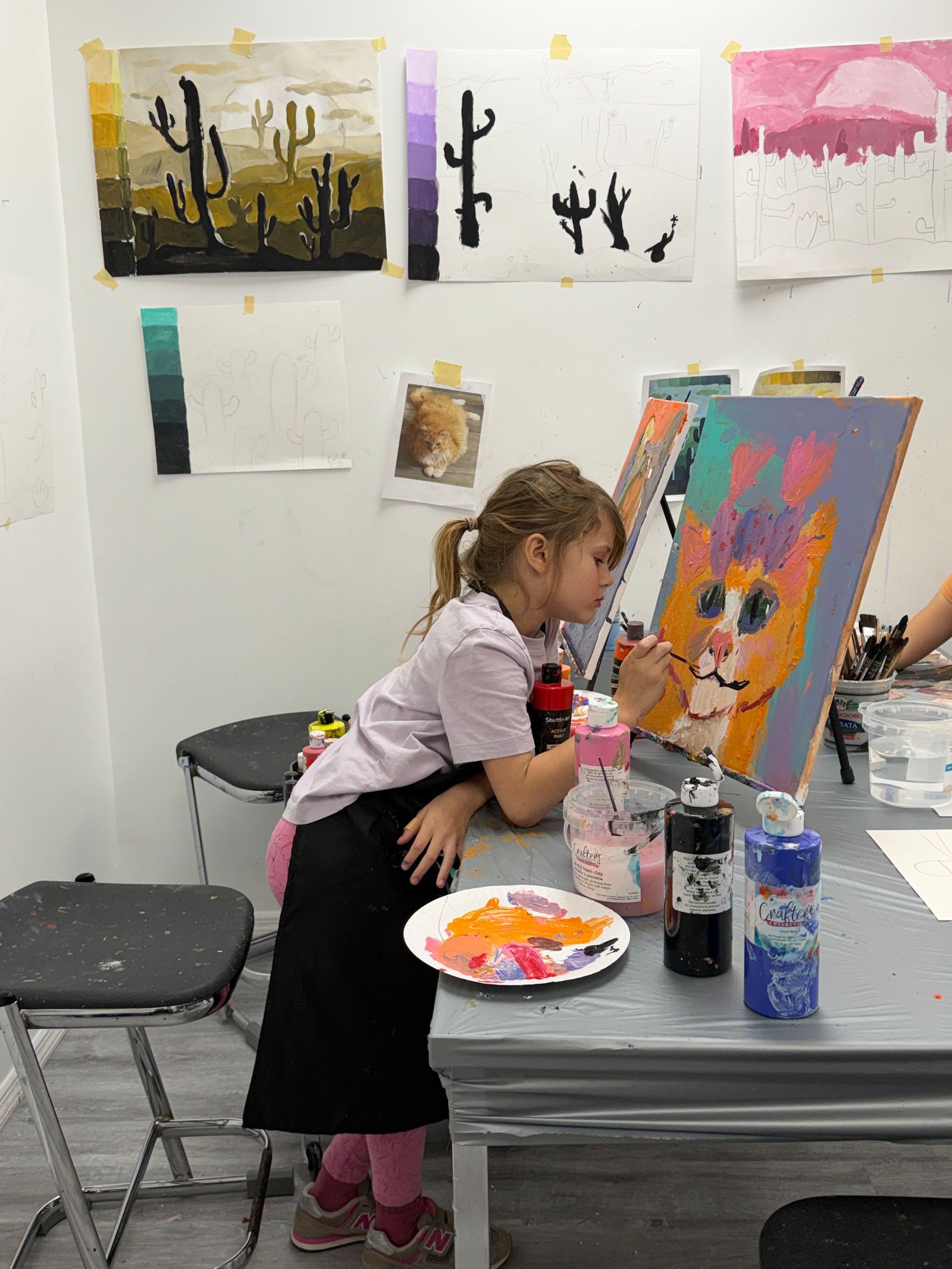 イーゼルの前で絵を描く女の子。入間市の造形・絵画の習い事のイメージ