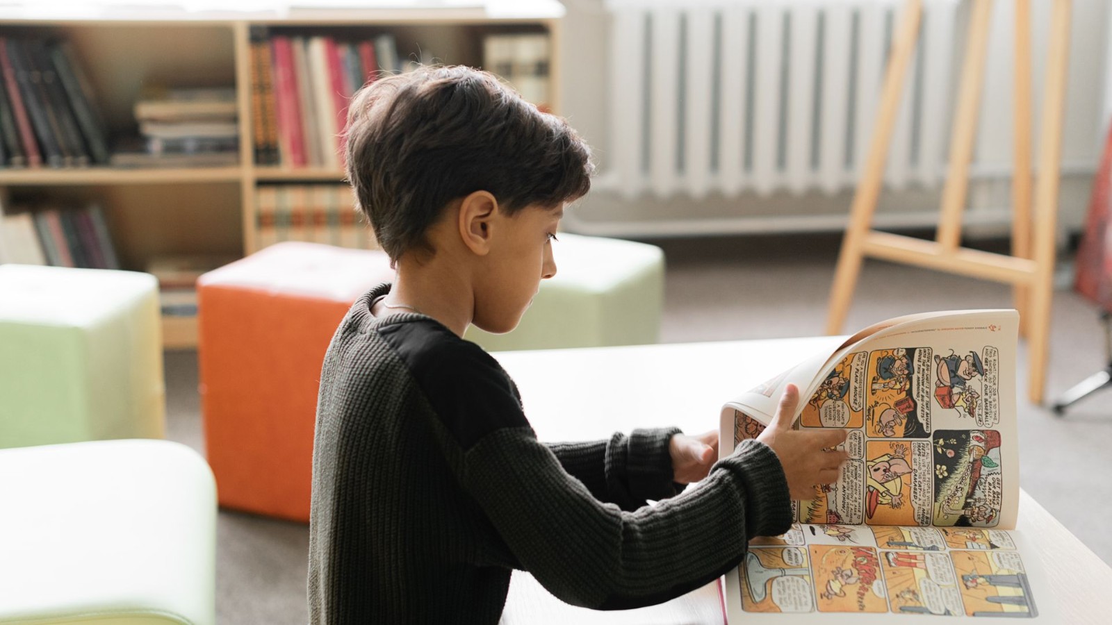 部屋で本を読む男の子
