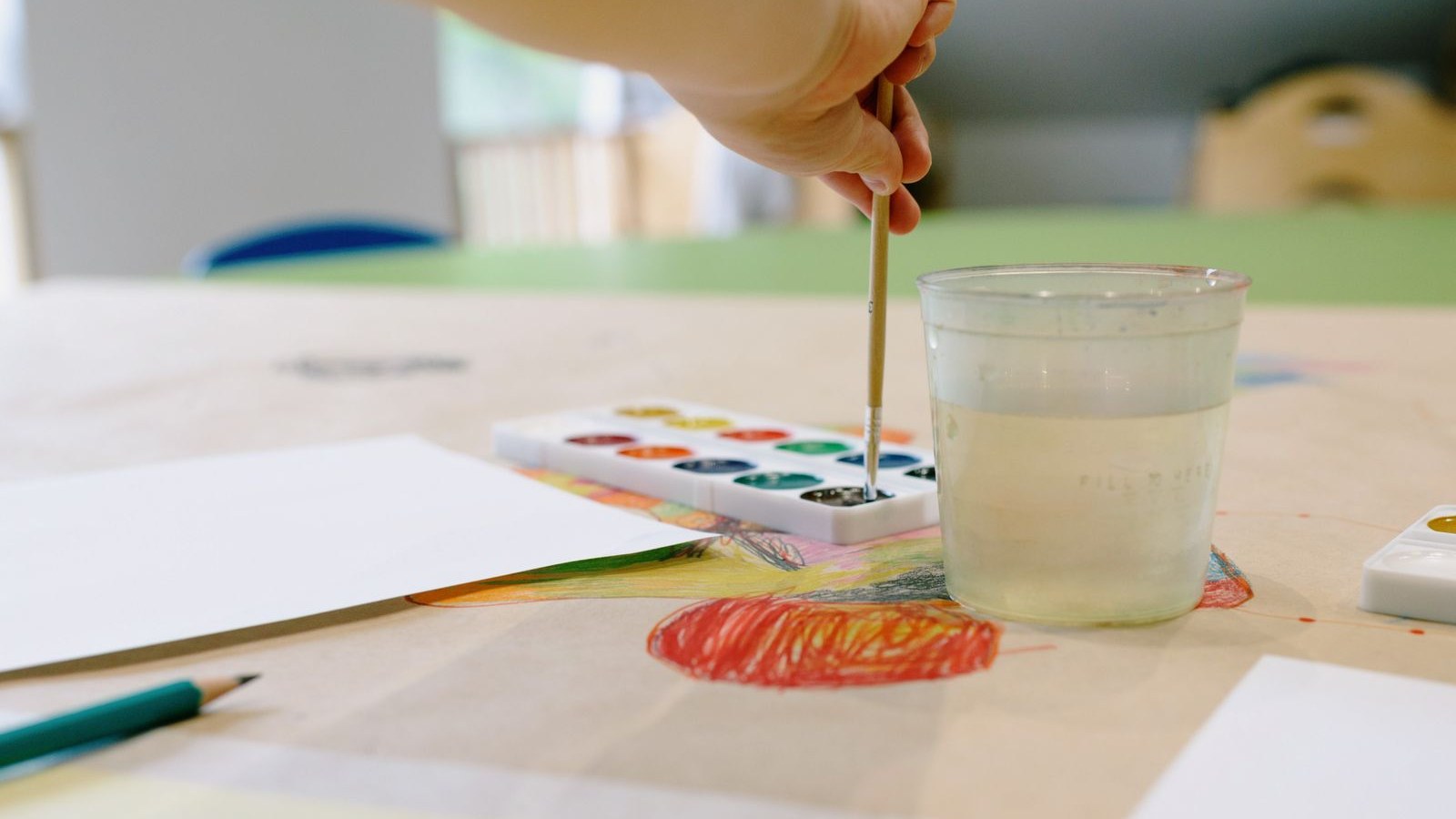 絵の具で絵を描く子どもの教室の机の上