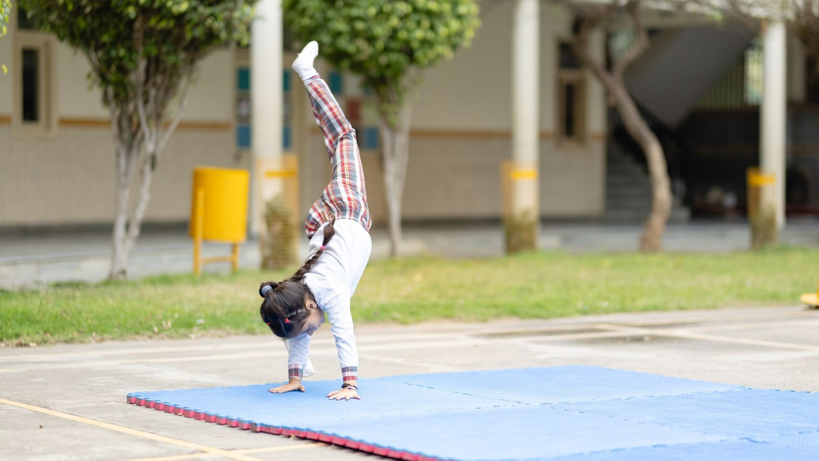 マットの上で体操の練習をする子ども